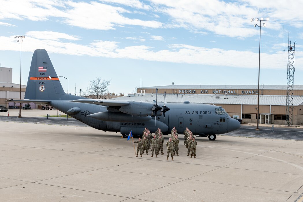 Airmen posing in front of aircraft for unit photo.