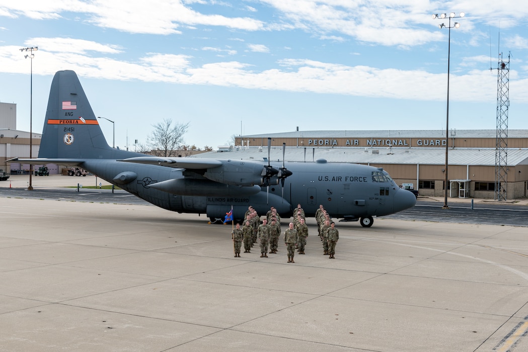 Airmen posing in front of aircraft for unit photo.