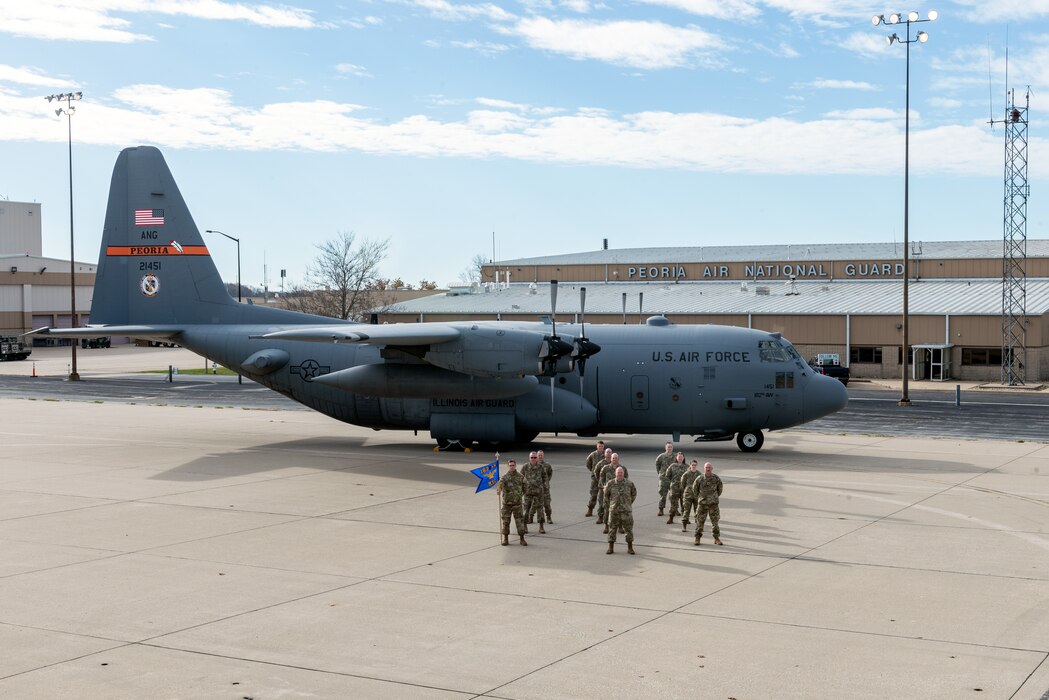 Airmen posing in front of aircraft for unit photo.