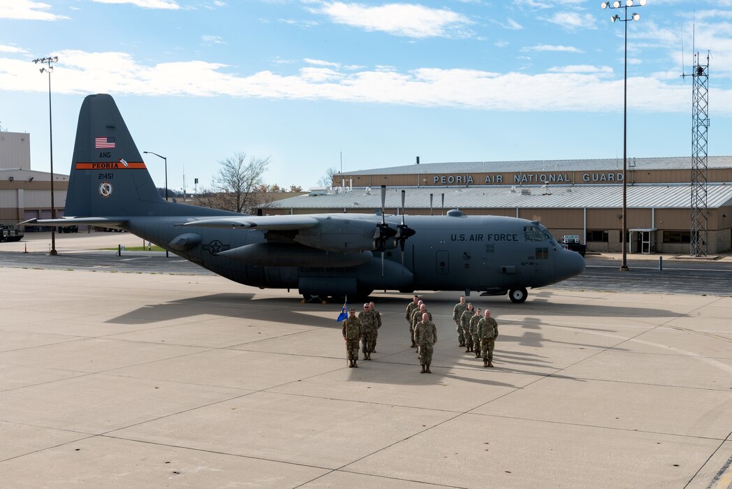 Airmen posing in front of aircraft for unit photo.