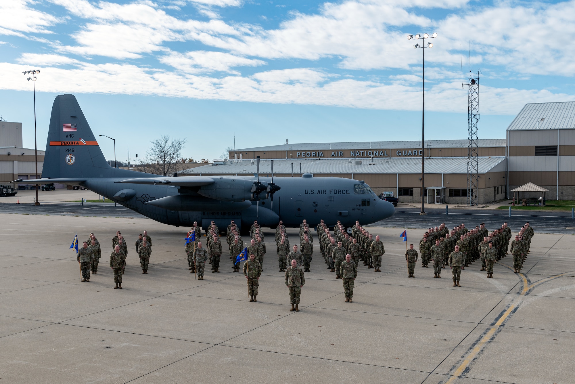 Airmen posing in front of aircraft for unit photo.