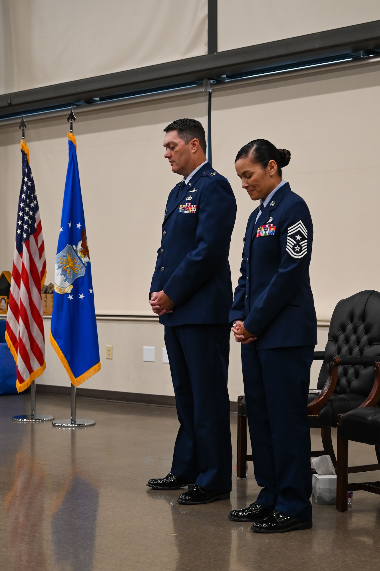 Col. Richard Erredge, 960th Cyberspace Wing commander, and Chief Master Sgt. Billie Baber, 960th CW command chief, bow their heads for the invocation during a retirement ceremony, Nov. 4, 2022, at Joint Base San Antonio-Lackland, Texas. Baber retired after dedicating 26 years to military service. (U.S. Air Force photo by Staff Sgt. Adriana Barrientos)