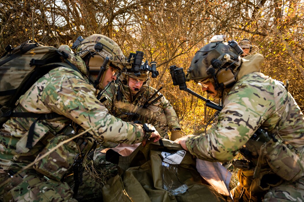 Airmen giving first aid to a medical dummy.