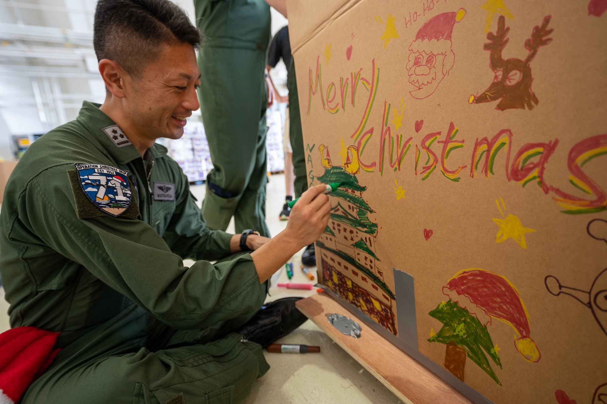 A man decorates a bundle box with colorful markers