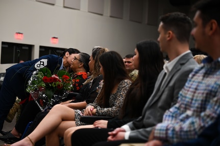 Ret. Chief Master Sgt. Billie Baber, former 960th Cyberspace Wing command chief, hands her mother flowers during her retirement ceremony, Nov. 4, 2022, at Joint Base San Antonio-Lackland, Texas. Baber entered the Air Force in 1996 and dedicated 26 years to military service. Baber’s husband and children also attended the ceremony. (U.S. Air Force photo by Staff Sgt. Adriana Barrientos)