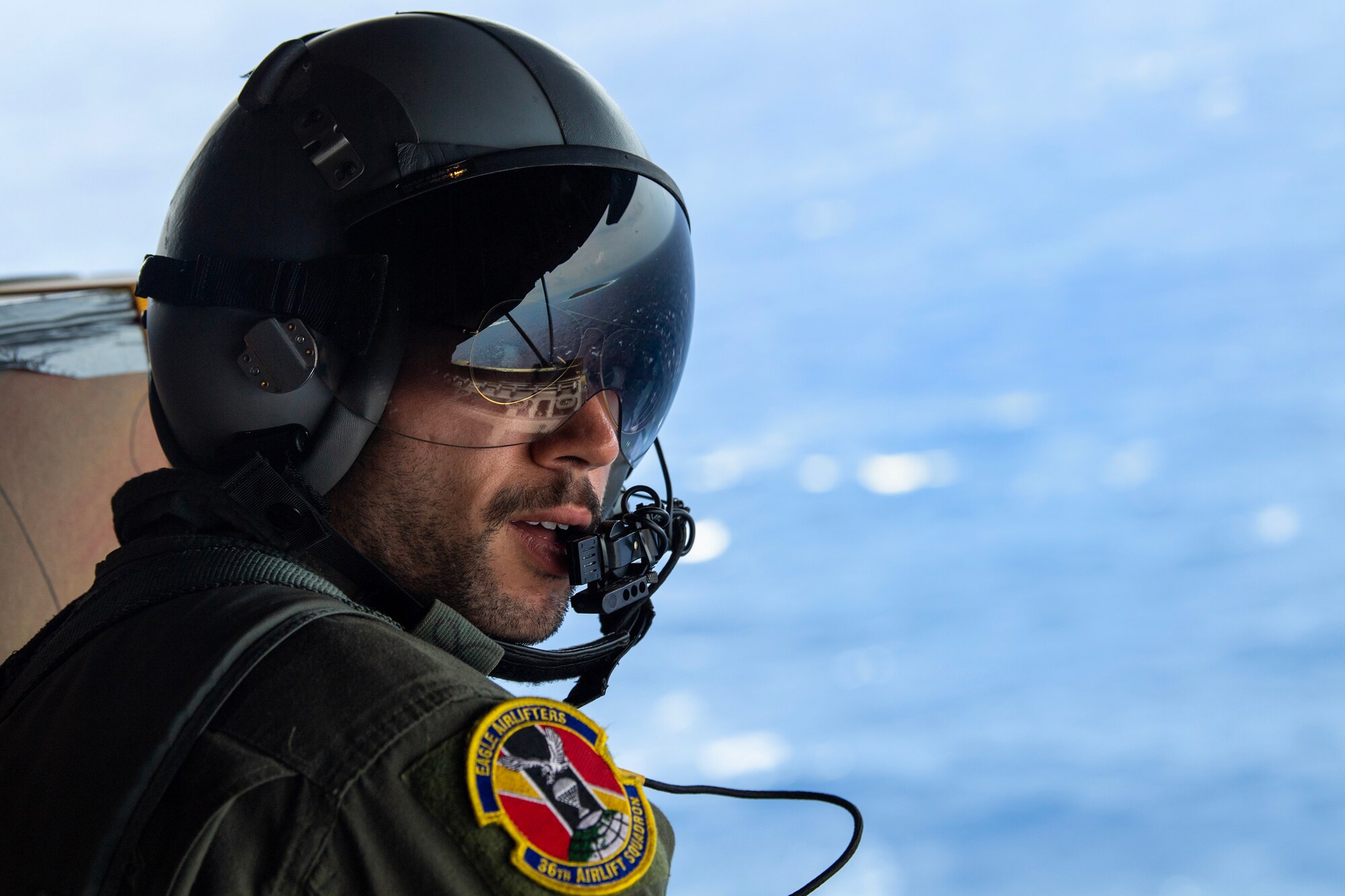 A man with a flightcrew helmet speaks into his microphone.