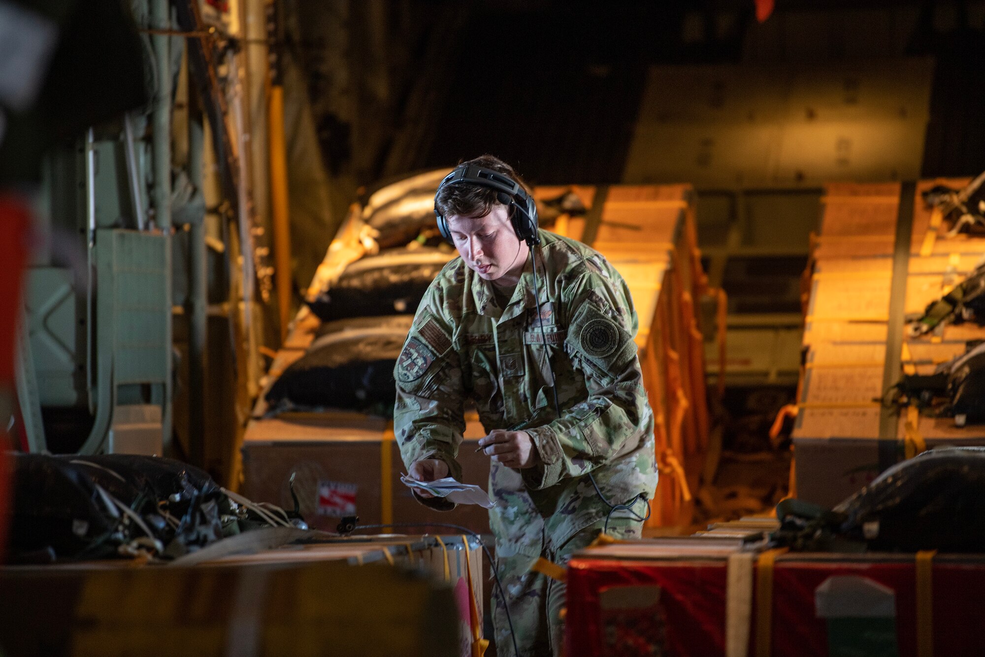 loadmaster checks bundles in the cargo area of a C-130J