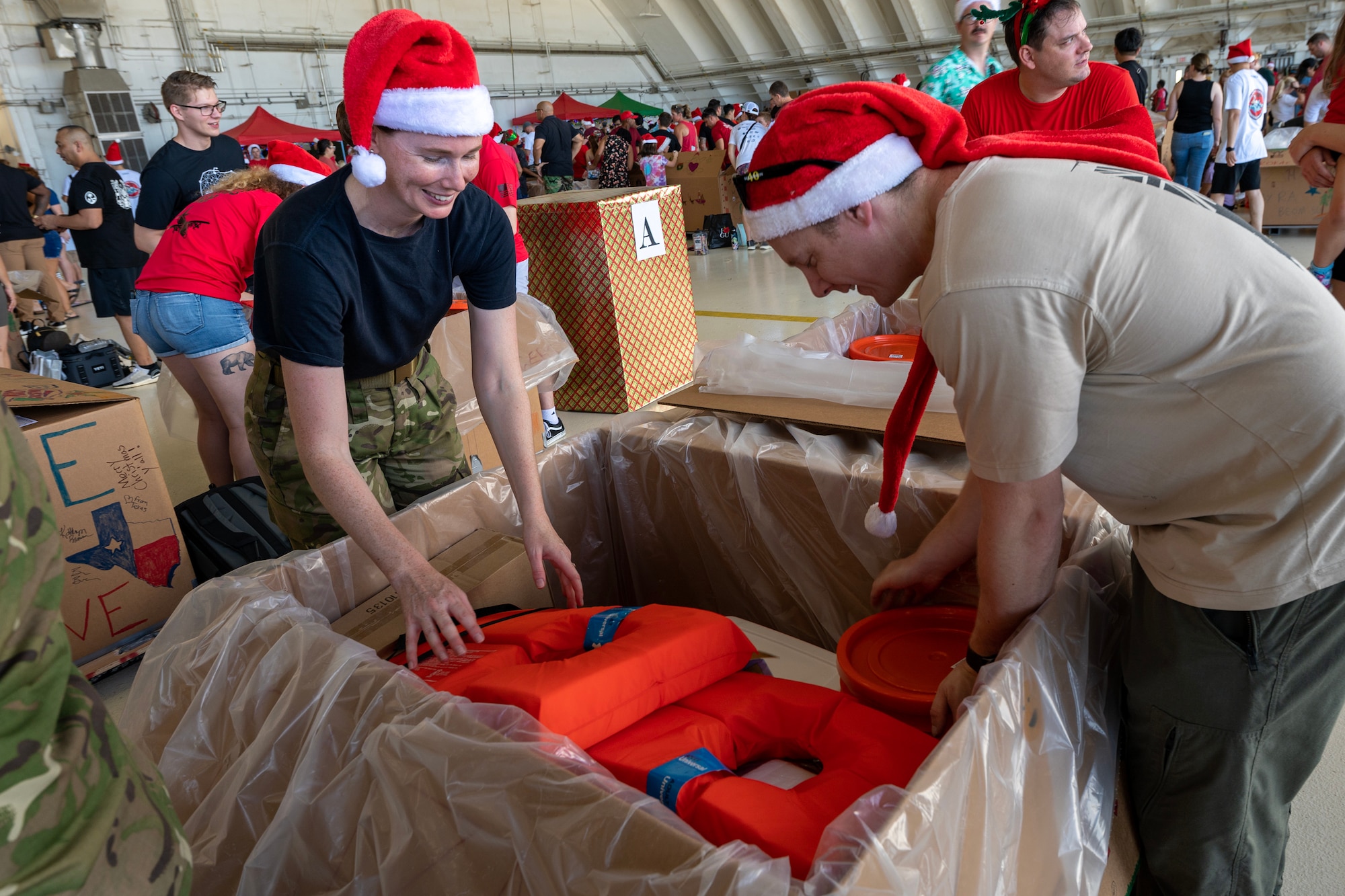 Operation Christmas Drop members add items to a box during Operation Christmas Drop