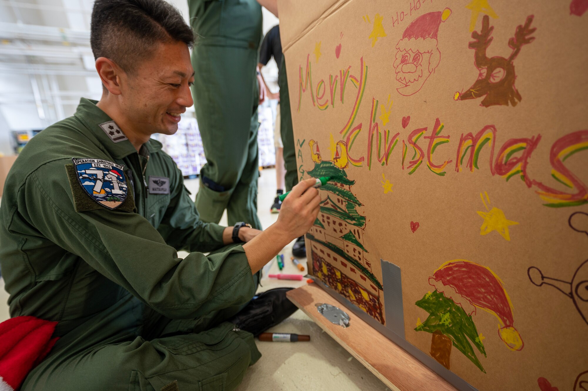 A man decorates a bundle box with colorful markers