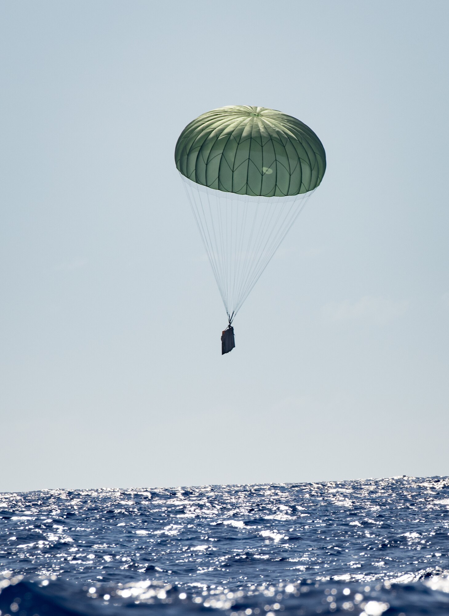 A practice bundle drops into the ocean near Andersen Air Force Base, Guam after being dropped by a Japan Air Self Defense Force C-130H Hercules