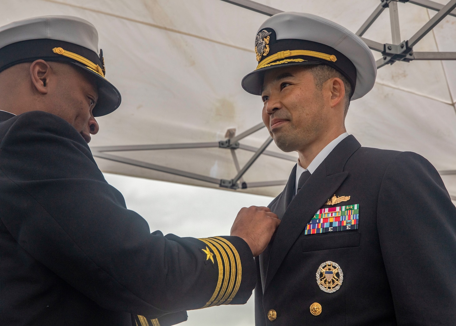 YOKOSUKA, Japan (Dec. 1, 2022) Cmdr. Kenji Igawa, incoming commanding officer of Arleigh Burke-class guided-missile destroyer USS Howard (DDG 83), receives his commanding officer’s pin from Capt. Walter Mainor, commander, Task Force 71, during a change of command ceremony aboard the ship, forward-deployed to Commander, Fleet Activities Yokosuka, Dec. 1. Howard is assigned to Commander, Task Force 71/Destroyer Squadron (DESRON) 15, the Navy’s largest forward-deployed DESRON and the U.S. 7th fleet’s principal surface force. (U.S. Navy photo by Mass Communication Specialist 2nd Class Samantha Oblander)