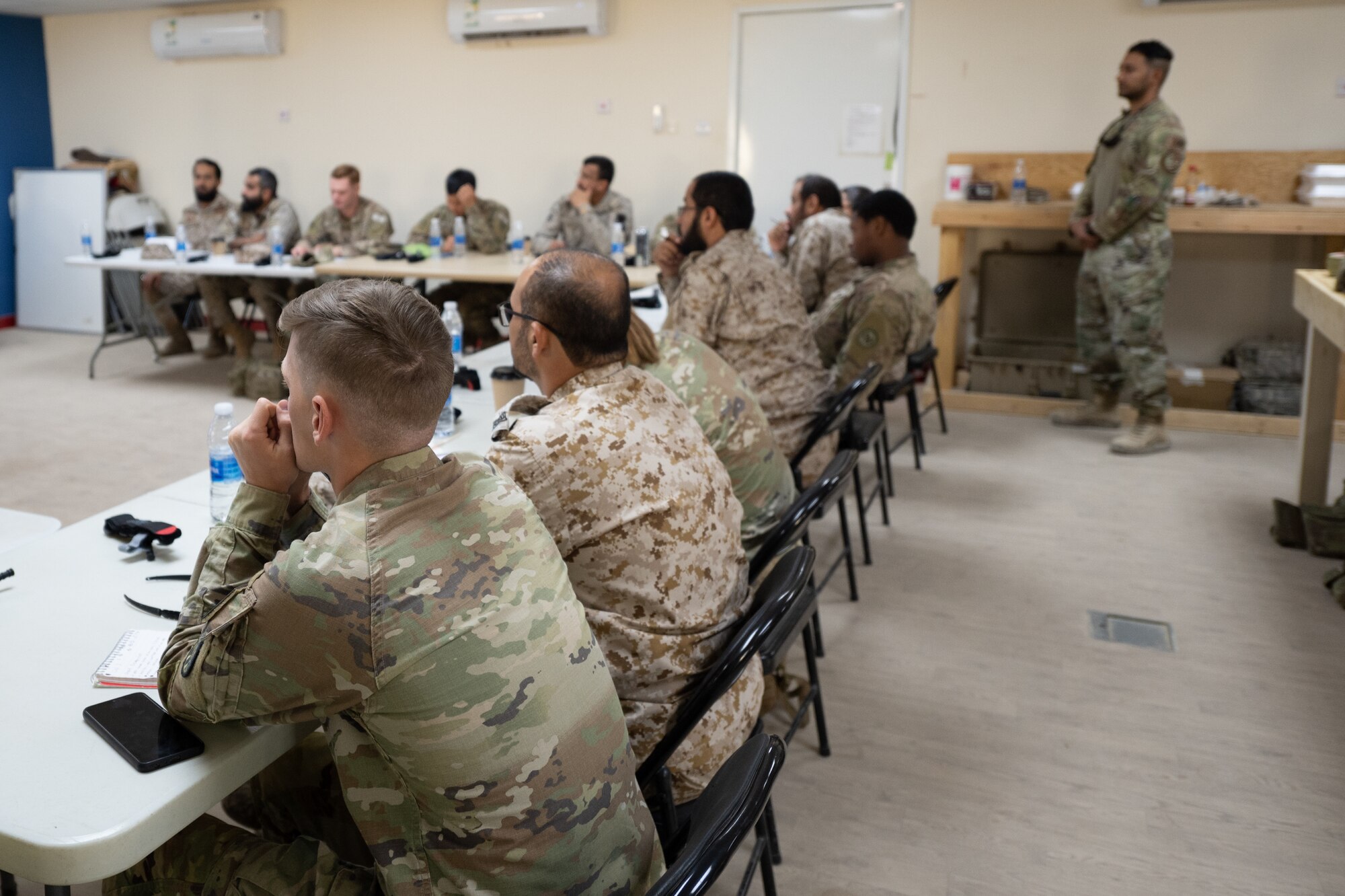 U.S. Army Soldiers assigned to Prince Sultan Air Base, and members of the Royal Saudi Land Forces listen in during a Tactical Combat Casualty Care training, Oct. 18, 2022.