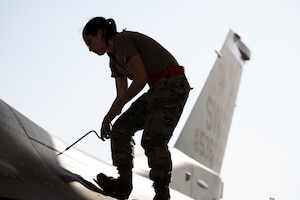 U.S. Air Force Staff Sgt. Lena Noel, a 77th Expeditionary Fighter Generation Squadron dedicated crew chief, fastens a screw on a panel of an F-16 Fighting Falcon aircraft, at Prince Sultan Air Base, Kingdom of Saudi Arabia Nov. 14, 2022.