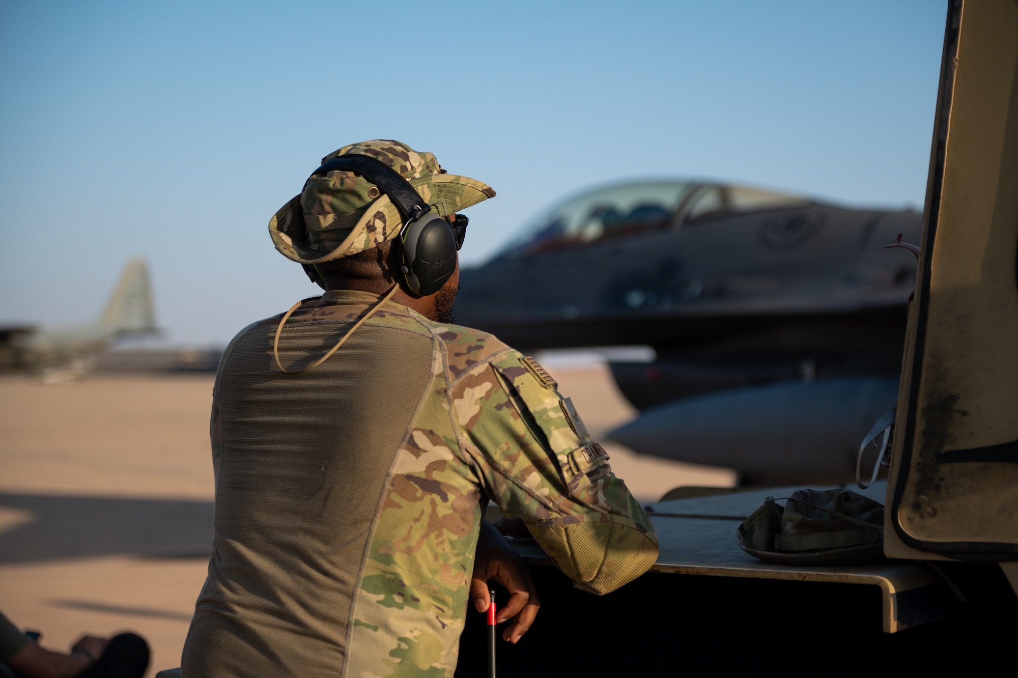 U.S. Air Force Airman 1st Class Jason Crawford, a 77th Expeditionary Fighter Generation Squadron engines technician, looks on during an F-16 Fighting Falcon after burner phase test, Nov. 14, 2022, at Prince Sultan Air Base, Kingdom of Saudi Arabia.  After