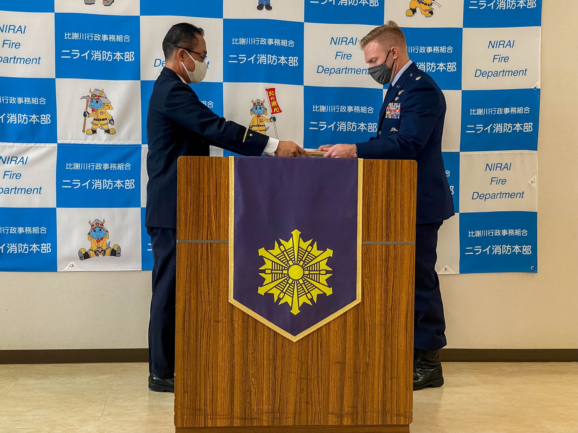 A member of the local fire department awards a member of the Air Force a certificate of appreciation