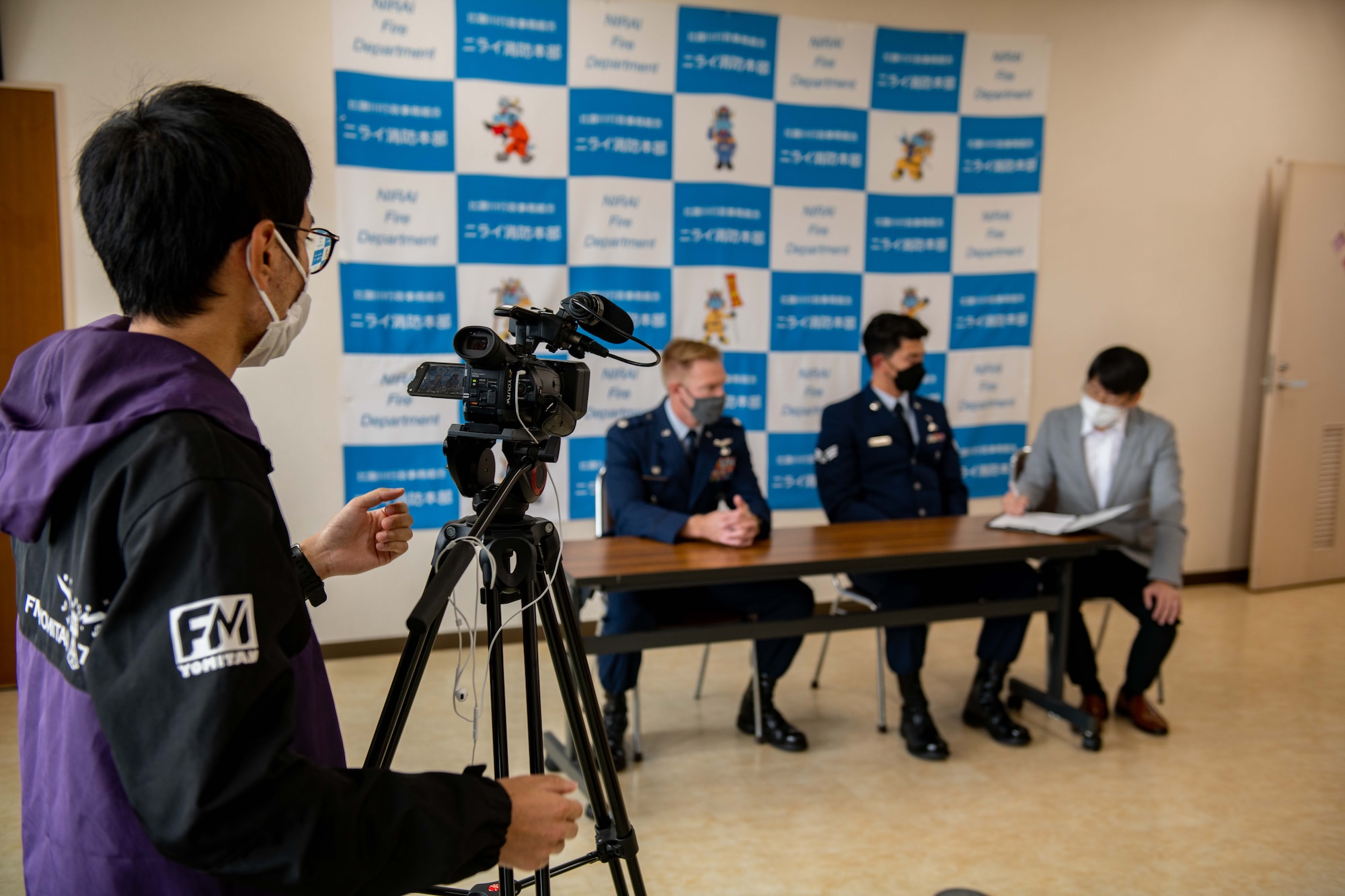 A member of the press records airmen during a press conference