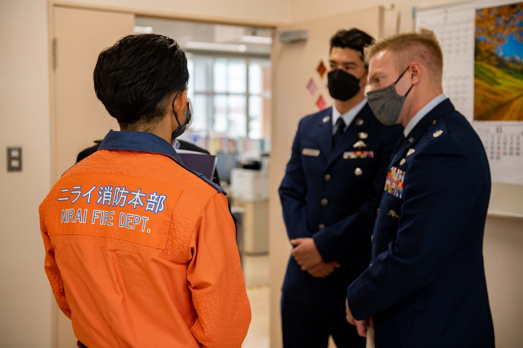 A Japanese fire fighter chats with two airmen
