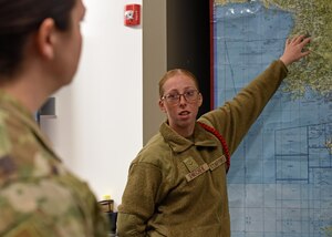 U.S. Air Force Airman 1st Class Leila Senechek, 315th Training Squadron student, briefs an instructor acting as a general officer during Operation Lone Star at Goodfellow Air Force Base, Texas, Nov. 28, 2022. Students spend five days collecting and utilizing data to create actionable intel to disseminate to instructors who act as leaders to make accurate and timely decisions. (U.S. Air Force photo by Airman 1st Class Sarah Williams)