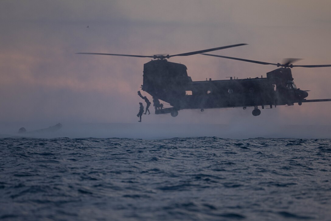 U.S. Marines with Bravo Company, 1st Reconnaissance Battalion, 1st Marine Division, jump from a U.S. Army MH-47 Chinook helicopter with 160th Special Operations Aviation Regiment during helocast training as part of Steel Knight 23 off the coast of Marine Corps Base Camp Pendleton, California, Dec. 2, 2022. Helocasting is a maritime insertion method for small units during amphibious operations. Steel Knight is an annual combined arms live-fire exercise which ensures 1st MARDIV is optimized for naval expeditionary warfare in contested spaces, and is purpose-built to facilitate future operations afloat and ashore. (U.S. Marine Corps photo by Cpl. Marshall)