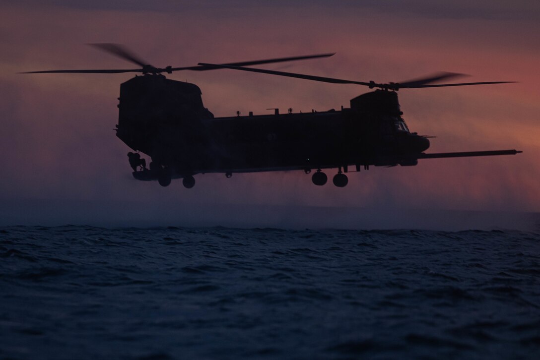 A U.S. Army MH-47 Chinook helicopter with 160th Special Operations Aviation Regiment hovers over the water as part of helocast training with Marines from Bravo Company, 1st Reconnaissance Battalion, 1st Marine Division, during Steel Knight 23 off the coast of Marine Corps Base Camp Pendleton, California, Dec. 2, 2022. Helocasting is a maritime insertion method for small units during amphibious operations. Steel Knight is an annual combined arms live-fire exercise which ensures 1st MARDIV is optimized for naval expeditionary warfare in contested spaces, and is purpose-built to facilitate future operations afloat and ashore. (U.S. Marine Corps photo by Cpl. Marshall)
