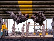 U.S. Marine Corps Recruits with Echo Company, 2nd Recruit Training Battalion, navigate the weaver obstacle during the confidence course at Marine Corps Recruit Depot San Diego, Nov. 28, 2022.