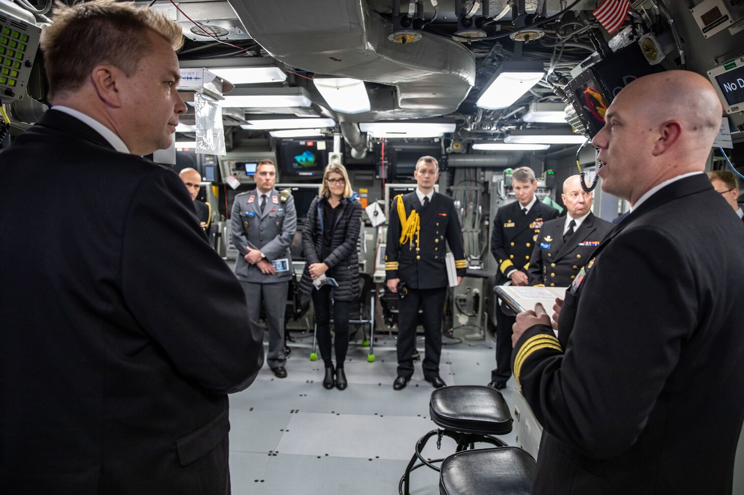 U.S. Navy Cmdr. Matthew Plant, right, executive officer of the San Antonio-class amphibious transport dock ship USS Arlington (LPD 24), gives the Honorable Antti Kaikkonen, left, Finnish Minister of Defense, a tour of Arlington’s combat information center at Naval Station Norfolk, Virginia, Dec. 4, 2022.