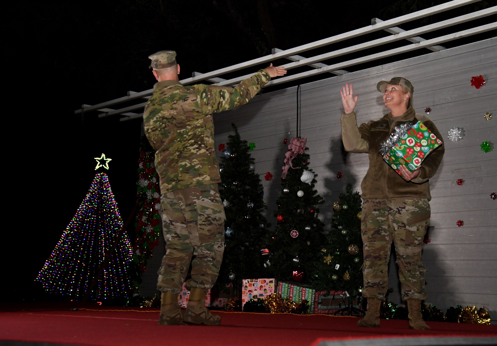 U.S. Air Force Col. William Hunter, 81st Training Wing commander, and Chief Master Sgt. Sarah Esparza, 81st TRW command chief, participate in a tree lighting ceremony during Holiday in the Park at Keesler Air Force Base, Mississippi, Dec. 1, 2022.