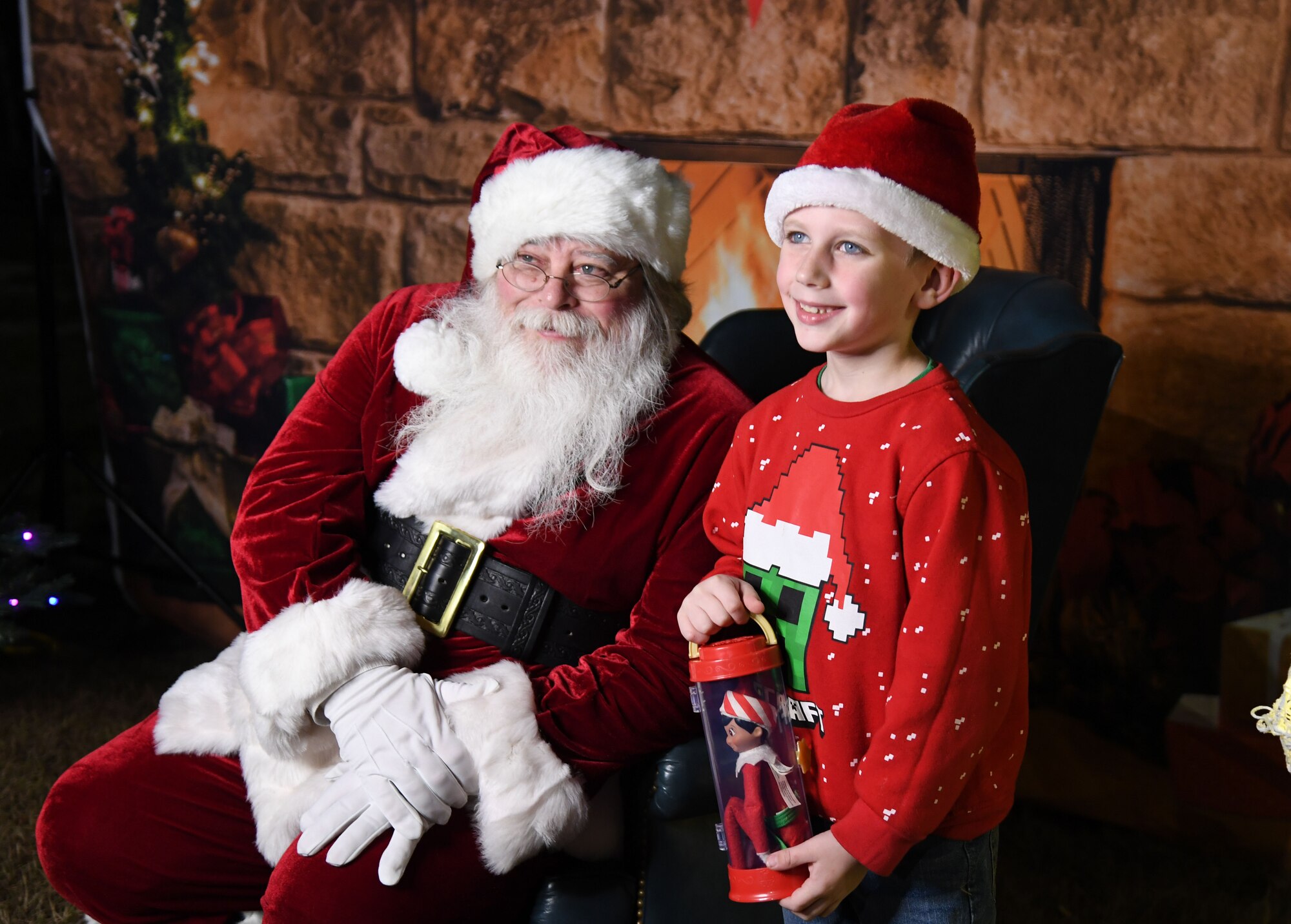 Vincent Randall, son of Allison Randall, 81st Healthcare Operations Squadron picture archival communication systems administrator, poses for a photo with Santa during Holiday in the Park at Keesler Air Force Base, Mississippi, Dec. 1, 2022.