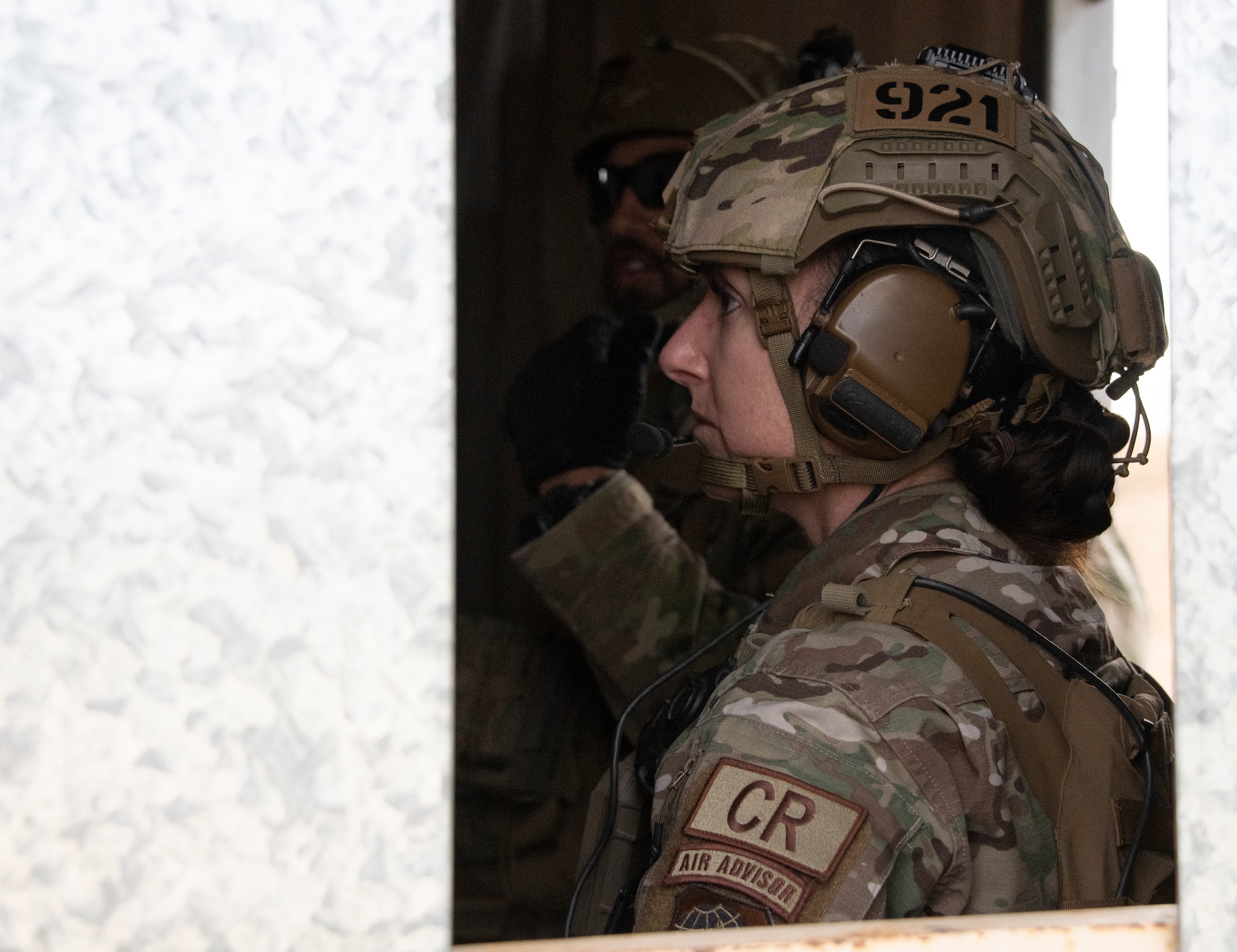 View of Airman wearing a helmet though a window.