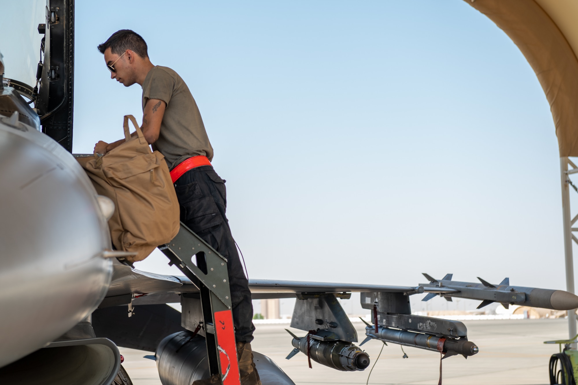 U.S. Air Force Senior Airman Stace Bechtel, a 77th Expeditionary Fighter Generation Squadron crew chief, stands on top of a ladder, prior to launching an F-16 Fighting Falcon, from Prince Sultan Air Base, Kingdom of Saudi Arabia Nov. 14, 2022.