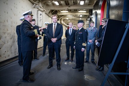 U.S. Navy Cmdr. Matthew Plant, left, executive officer of the San Antonio-class amphibious transport dock ship USS Arlington (LPD 24), gives the Honorable Antti Kaikkonen, center, Finnish Minister of Defense, a tour of the Arlington at Naval Station Norfolk, Virginia, Dec. 4, 2022.