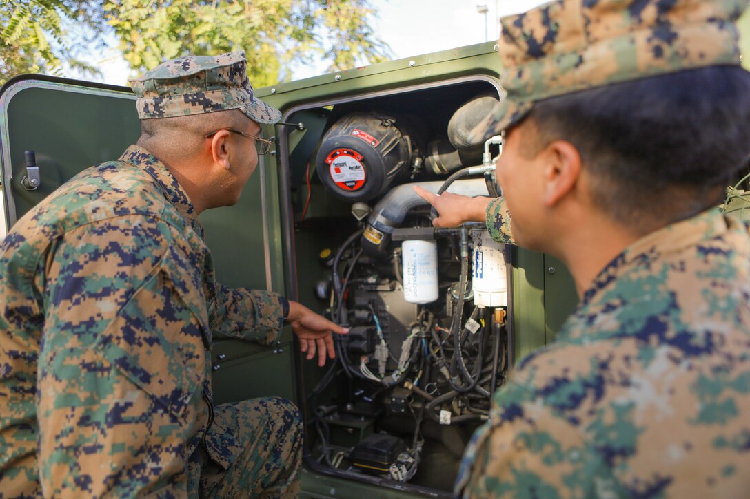 U.S. Marine Corps Cpl. Alex Carrillo Orantes, left, and Lance Cpl. Andrew Barbosa, both engineer equipment electrical systems technicians with 1st Intelligence Battalion, I Marine Expeditionary Force Information Group, perform preventative maintenance on a MEP-1070 generator in support of Steel Knight 23 at Marine Corps Base Camp Pendleton, Nov. 29, 2022. SK23 is a 1st Marine Division-led annual training exercise which enables the Navy-Marine Corps team to operate in a realistic, combined-arms environment to enhance naval warfighting tactics, techniques and procedures. (U.S. Marine Corps photo by Cpl. Amelia Kang)