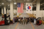 People standing in front of military and national flags