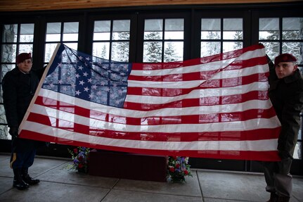 U.S Army honor guard Soldiers unfold an American flag during an unaccompanied funeral service for the remains of five veterans at the Fort Richardson National Cemetery on Joint Base Elmendorf-Richardson, Alaska, Nov. 30, 2022. The Department of Military and Veterans Affairs works jointly with the federally recognized non-profit organization Missing in American Project in locating, identifying and interring the unclaimed cremated remains of veterans with full honors and ceremony. (Alaska National Guard photo by Victoria Granado)