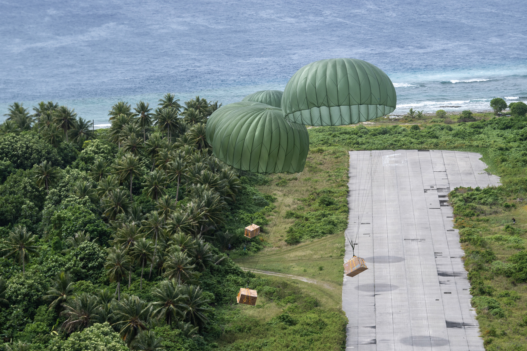 Bundles descend from a U.S. Air Force C-130J Super Hercules for Operation Christmas Drop.