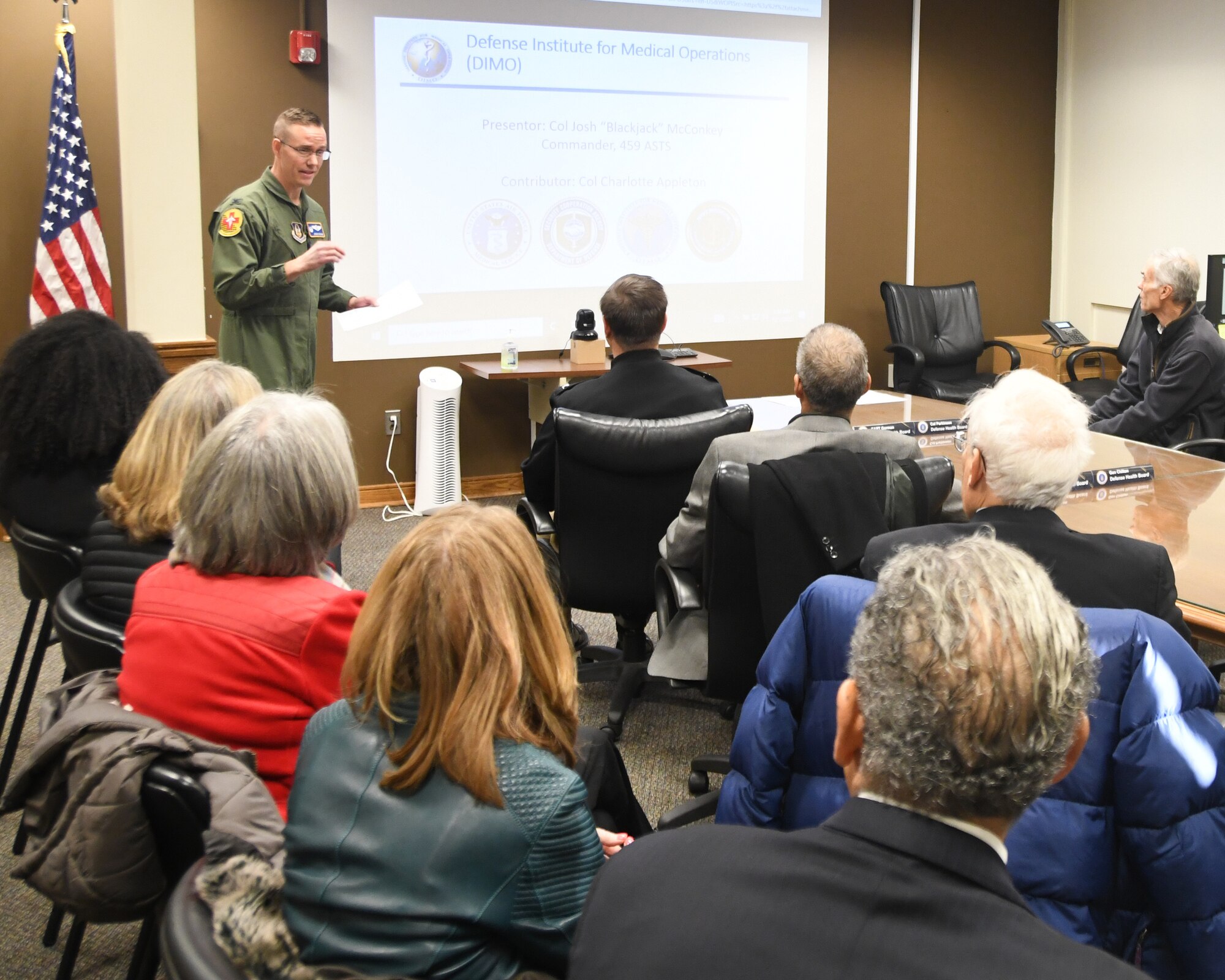 Col. Joshua McConkey, 459th Aeromedical Staging Squadron Commander, provides a briefing to Defense Health Board members during their visit to the 459th ARW on Dec. 1, 2022. The DHB requested a visit to Joint Base Andrews for an opportunity to see the pivotal role medical units at Joint Base Andrews play in the global patient movement pipeline and the challenges faced in supporting this critical effort. (U.S. Air Force Photo by Maj. Tim Smith)
