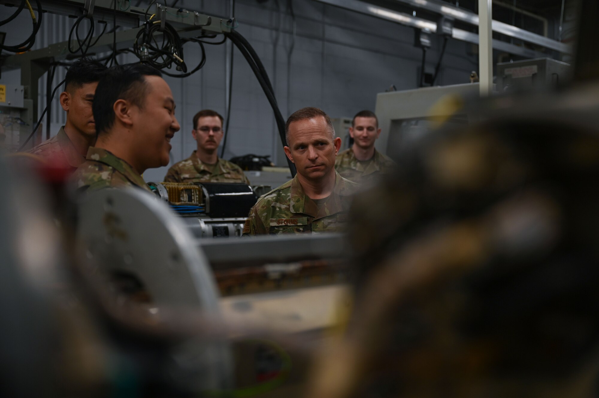 U.S. Air Force Staff Sgt. Chrisjian Yang, 36th Electronic Warfare Squadron technician, left, briefs Command Chief Master Sgt. John Storms, Air Combat Command, right, during his visit at Eglin Air Force Base, Fla., Nov. 30, 2022. Yang explained how Airmen from the 36th EWS deliver adaptive and cutting-edge electromagnetic spectrum capabilities that provide the warfighter a tactical and strategic competitive advantage and freedom to attack, maneuver, and defend. (U.S. Air Force photo by Staff Sgt. Ericka A. Woolever)