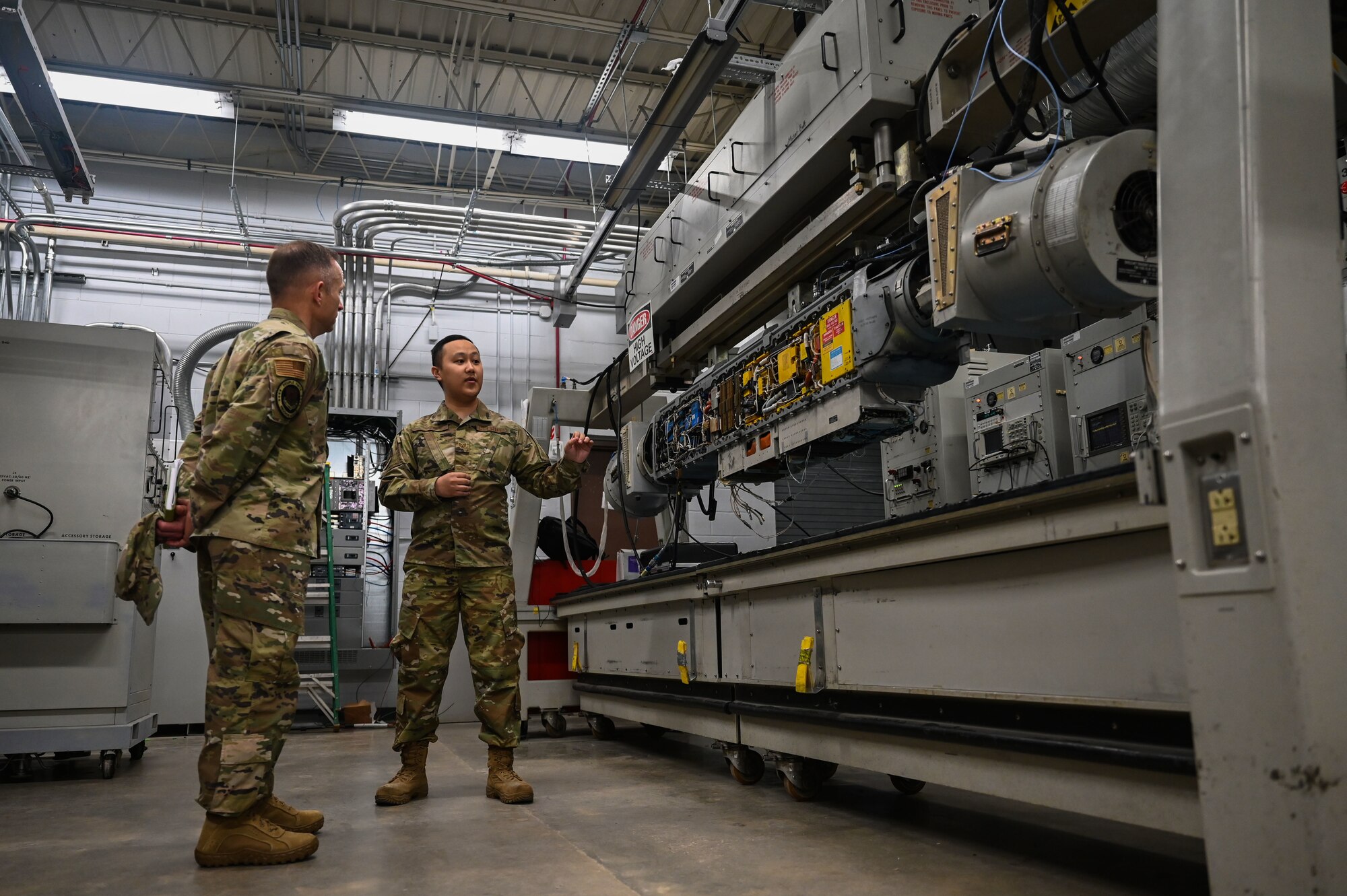 U.S. Air Force Command Chief Master Sgt. John Storms, Air Combat Command, listens to a brief by members of the 36th Electronic Warfare Pod Shop at Eglin Air Force Base, Fla., Nov. 30, 2022. The 36th EWS Pod Shop recently created the Reclamation of Electronic Attack Pods (REAP) Program which reuses parts of old pods to repair current pods for mission use. (U.S. Air Force photo by 1st Lt. Benjamin Aronson)