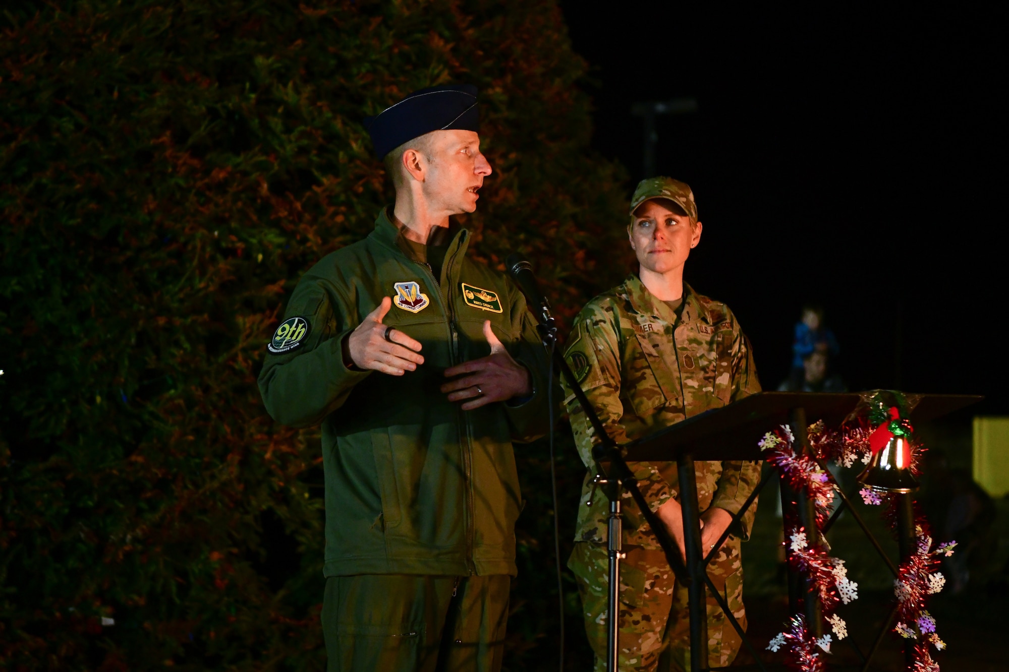 Col. Geoffrey Church, 9th Reconnaissance Wing commander, and Command Chief Master Sgt. Breana Oliver, 9th Reconnaissance Wing command chief, deliver opening remarks during the Christmas tree lighting event at Beale Air Force Base, Calif., on Dec. 2, 2022.