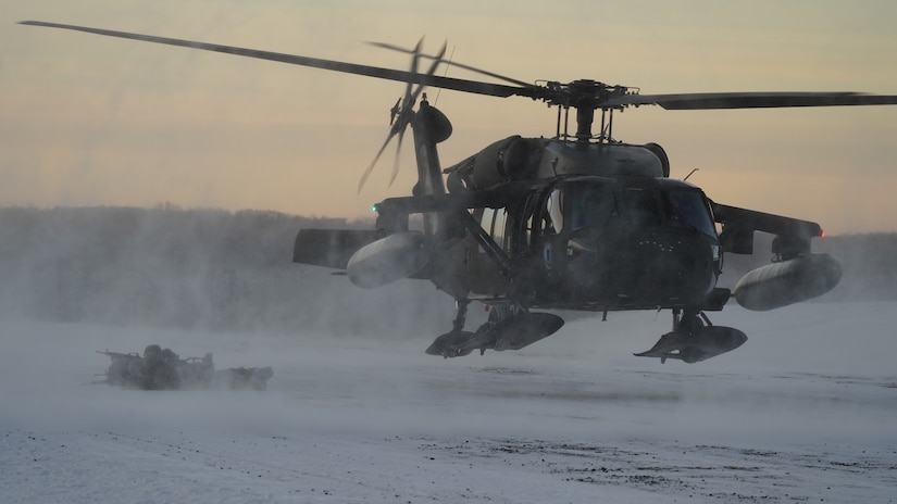An Alaska Army National Guard UH-60L Black Hawk helicopter assigned to 1-207th Aviation Regiment delivers a squad of University of Alaska Army ROTC Cadets to their designated landing zone at Joint Base Elmendorf-Richardson, Alaska, Dec. 2.  The Seawolf ROTC Detachment continued maneuvering across more than one mile of frozen terrain to assault opposition forces and secure its objective. The Alaska Army National Guard’s General Support Aviation Battalion routinely trains with all branches of the military as well as civilian agencies to increase its operational interoperability and to be ready for a wide range of federal and state missions.