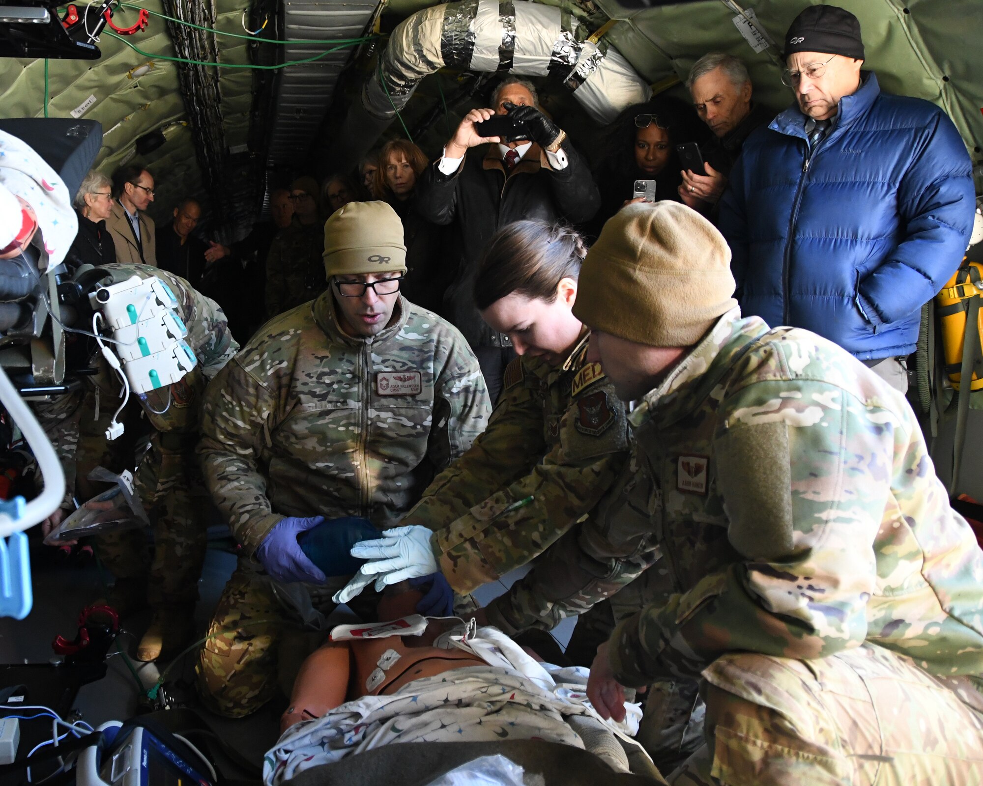 Chief Master Sgt. Adam, Willemssen, Tech Sgt. Rebecca Gollihugh, and Maj. Aaron Rankin, all of the 459th Aeromedical Evacuation Squadron, conduct medical training in front of members of the Defense Health Board during the board’s visit to the 459th ARW on Dec. 1, 2022. The training took place aboard one of the wing’s KC-135 Stratotankers. The DHB requested a visit to Joint Base Andrews for an opportunity to see the pivotal role medical units at Joint Base Andrews play in the global patient movement pipeline and the challenges faced in supporting this critical effort. (U.S. Air Force Photo by Maj. Tim Smith)