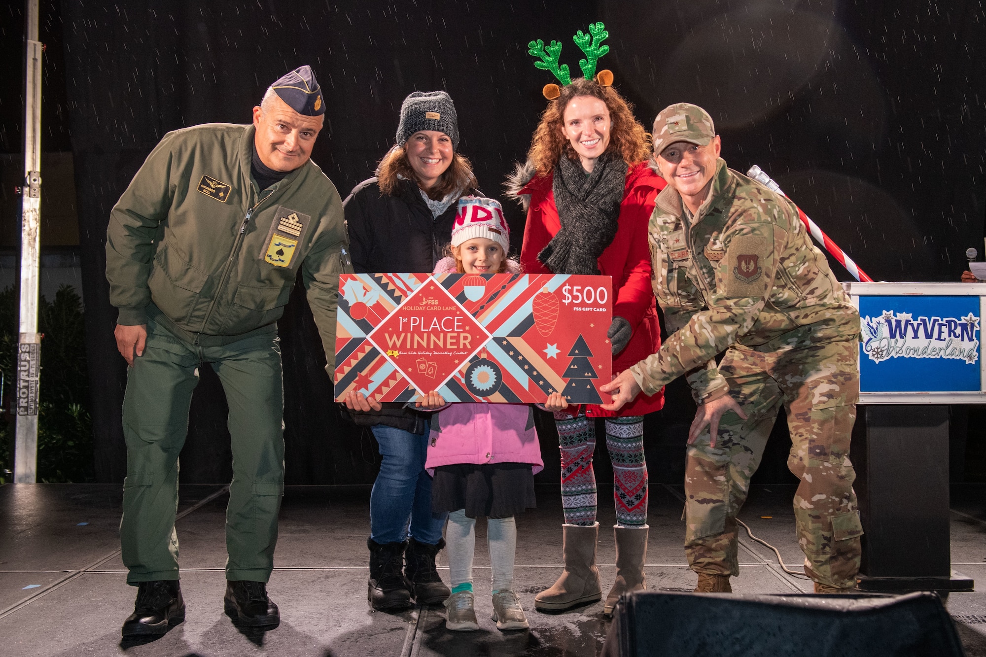 U.S. Air Force Brig. Gen. Tad Clark, 31st Fighter Wing commander, far right, and Italian Air Force Lt. Col. Riccardo Isoli, operations chief, far left, present the first place for the holiday card decoration contest prize to representatives from the 555th Fighter Squadron, middle, during the Wyvern Wonderland holiday event