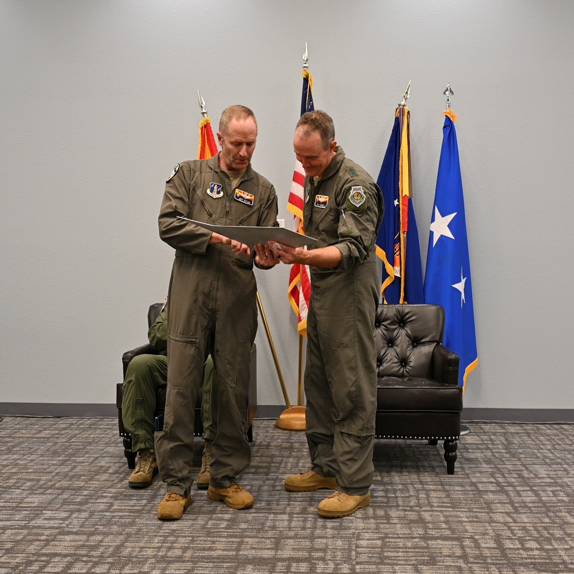 Maj. Gen. Howard P. Purcell, Assistant Adjutant General for Air, Air Component Commander of the Arizona Air National Guard and Air National Guard Assistant to the Secretary of the Air Force, International Affairs, a former 162nd Wing Commander accepts a token of appreciation from Brig. Gen. Jefferey L. Butler during an informal retirement ceremony at Morris Air National Guard Base, Dec. 3. (U.S. Air National Guard photo by Capt. Lacey Perry)