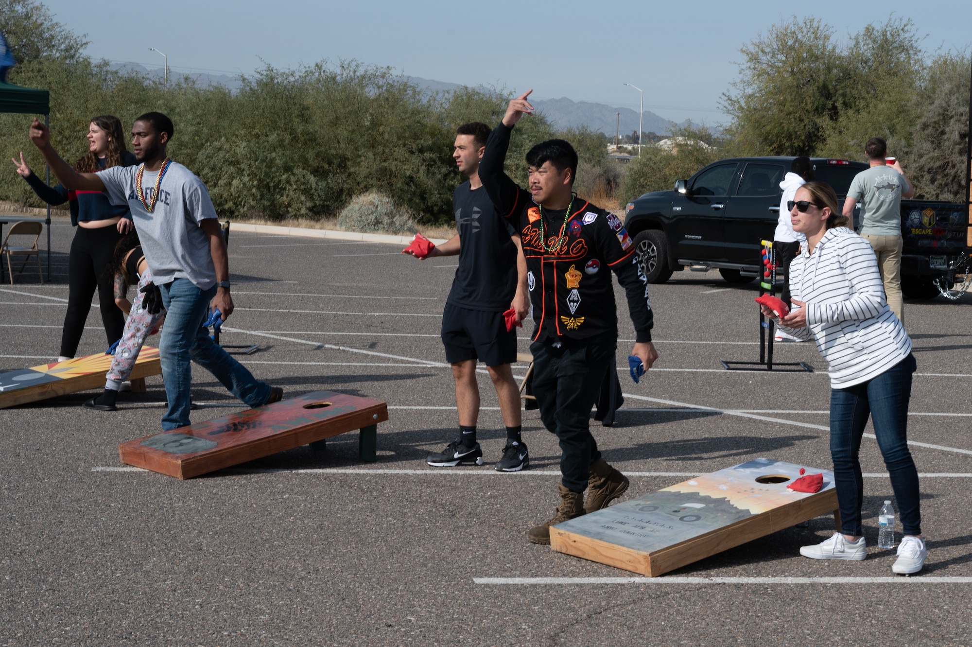 Airmen assigned to the 56th Equipment Maintenance Squadron and family members participate in a cornhole tournament during the Saint Barbara’s Day Cactus Bash celebration Dec. 4, 2022, at Luke Air Force Base, Arizona.