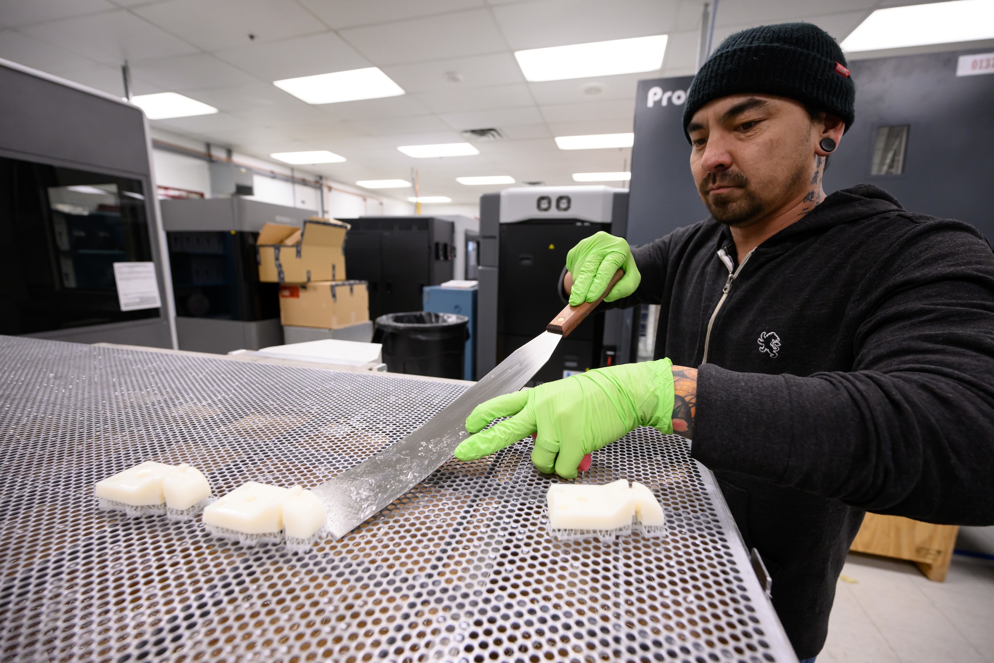 Jamie Endow, 809th Maintenance Support Squadron engineering technician, removes printed parts from a wash rack at Hill Air Force Base, Utah, Dec. 2, 2022. (U.S. Air Force photo by R. Nial Bradshaw)