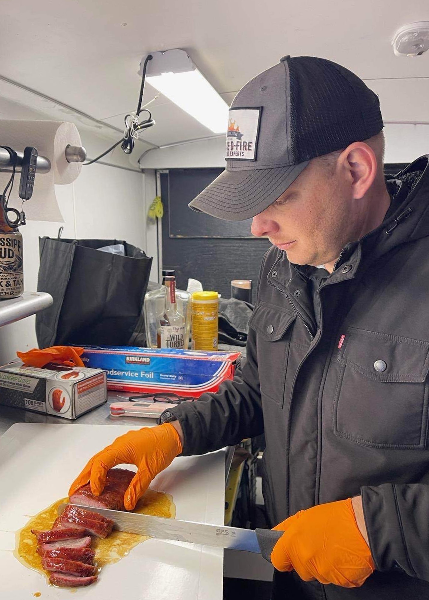 Master Sgt. Woolverton prepares a cut of meat for a barbeque competition.