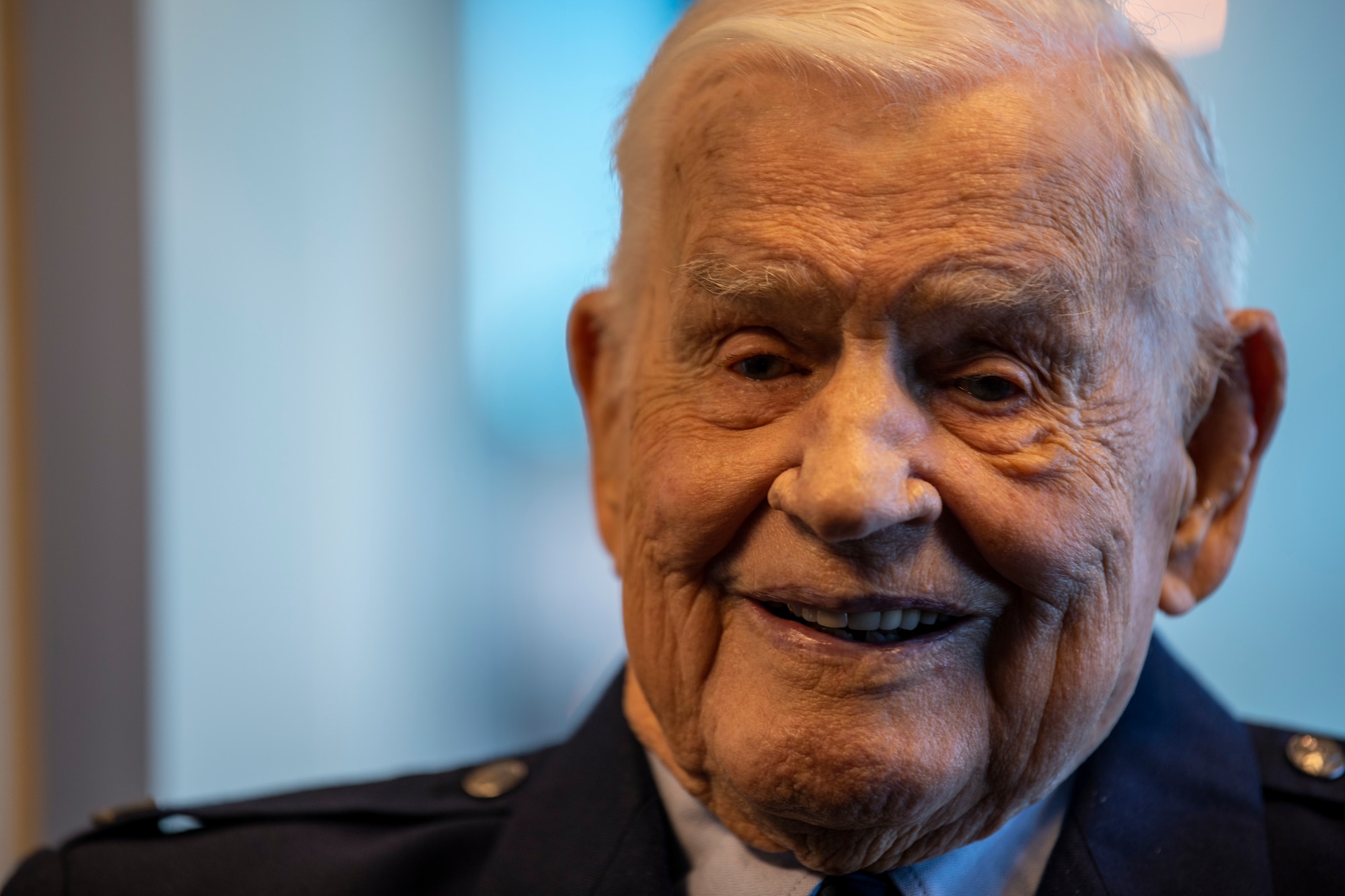 A close portrait of an elderly man smiling.