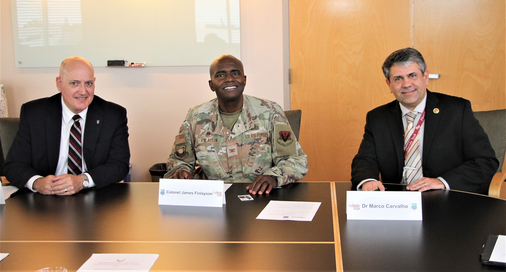 The three signatories of the Cooperative Research and Development Agreement between the Air Force Technical Applications Center and Florida Institute of Technology pose for a photo Nov. 15, 2022, before signing the agreement at a symbolic ceremony at the university’s Melbourne, Fla., campus.  Pictured from left to right are Dr. Daniel DeForest, AFTAC’s Director of Strategic Integration; Col. James A. Finlayson, AFTAC Commander; and Dr. Marco Carvalho, Florida Tech’s Executive Vice President, Provost, and Chief Operating Officer.  (Florida Institute of Technology photo by Adam Lowenstein)