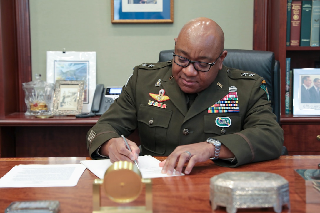 Maj. Gen. Isaac Johnson, Jr., commanding general, U.S. Army Civil Affairs and Psychological Operations Command (Airborne), signs the Memorandum of Understanding sealing a partnership between Rice University's Baker Institute for Public Policy and USACAPOC(A), in the office of former United States Secretary of State and White House Chief of Staff James Baker, III, at the Baker Institute, Houston, Texas, on November 28, 2022. The MOU is aimed at providing additional training opportunities to the U.S. Army Reserve’s Military Government Specialists (38G). (US Army Reserve photo by Sgt. 1st Class Lisa M Litchfield)