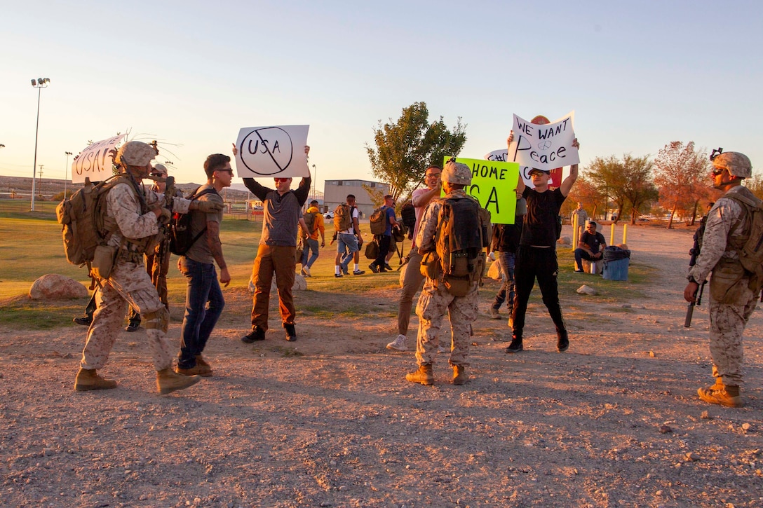 U.S. Marines with 2nd Battalion, 7th Marine Regiment, conduct crowd control on role-players during a noncombatant evacuation operation (NEO) exercise at Marine Corps Air Ground Combat Center, Twentynine Palms, California, Oct. 27, 2022. The NEO simulated real-life scenarios for Marines to practice the evacuation of noncombatants from potentially dangerous areas. (U.S. Marine Corps photo by Lance Cpl. Jacquilyn Davis)